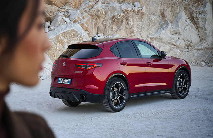 alfa romeo Stelvio vista da dietro con donna che la guarda