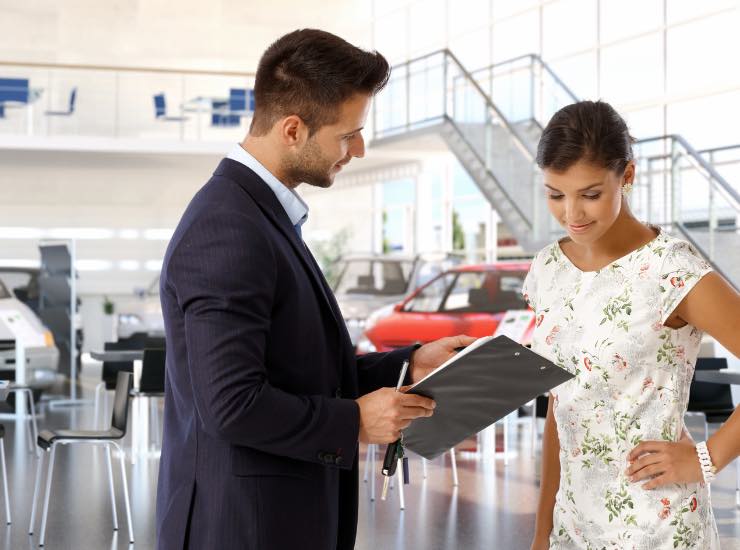 Due persone visionano dei documenti in un'autofficina