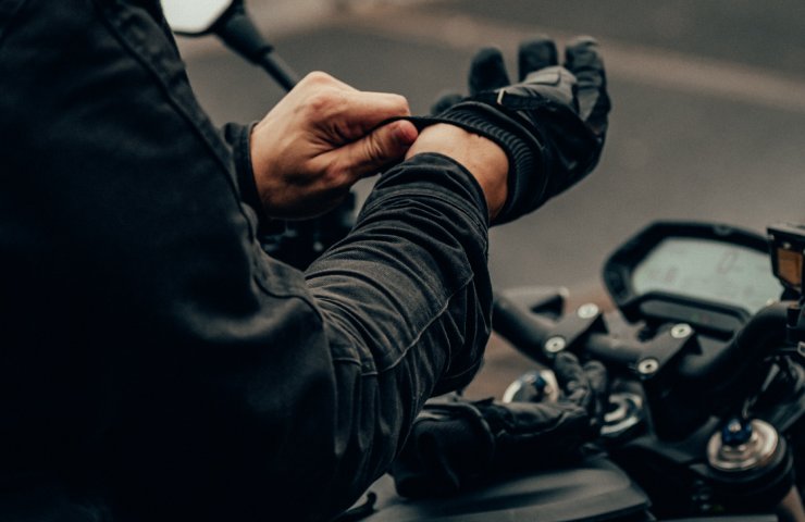 Motociclista indossa i guanti in moto