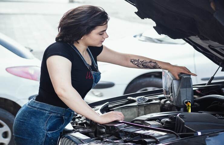 ragazza mette olio nel motore