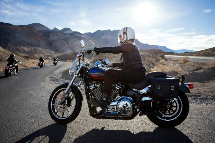 Persone in sella alle proprie moto mentre viaggiano in strada