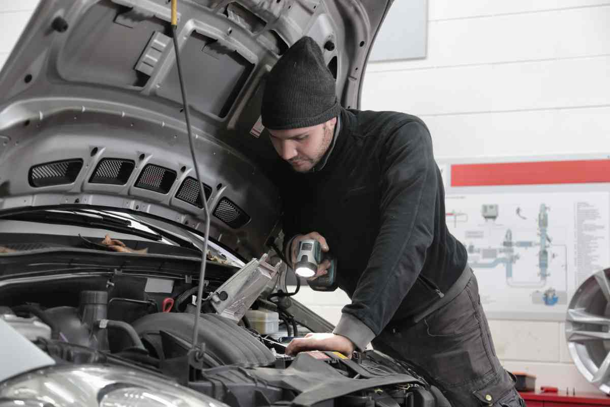 Meccanico che sistema un'automobile guasta