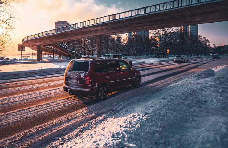 Macchina in viaggio su strada innevata